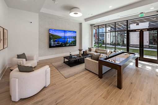 A modern living room with a flat screen TV mounted on the wall.