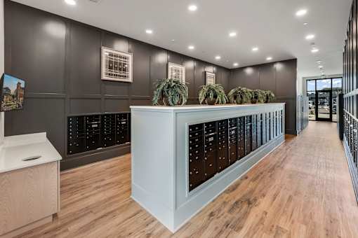 A long hallway with a white reception desk and a row of lockers on the wall.