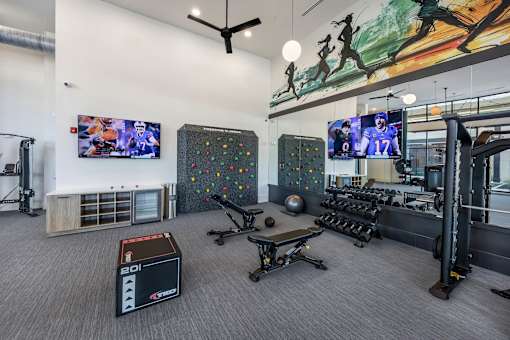 A gym with a variety of equipment including a box, a bench, and a ball.