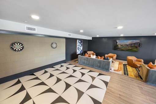 A room with a dartboard on the wall and a rug on the floor.