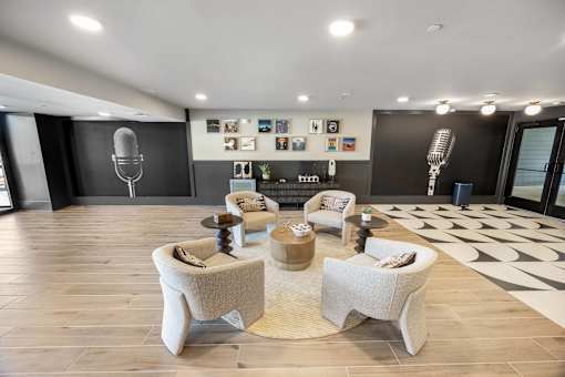 A modern living room with a large speaker and a collection of framed pictures on the wall.
