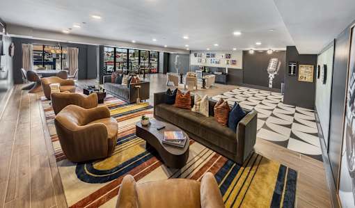 A modern living room with a variety of seating options and a large rug.