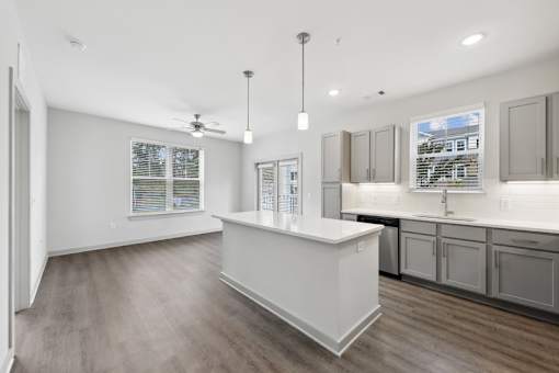 A kitchen with a white island and wooden floors.