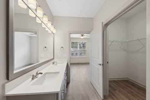 A bathroom with a white sink and mirror.