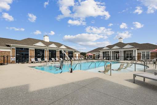 A large outdoor swimming pool with a slide and sun loungers.
