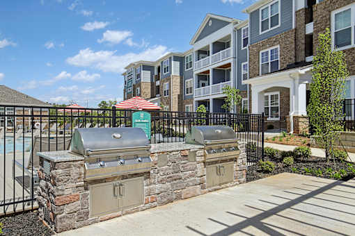 A bbq grill is in front of a building.