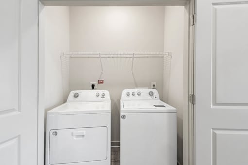 A white laundry room with a washer and dryer.