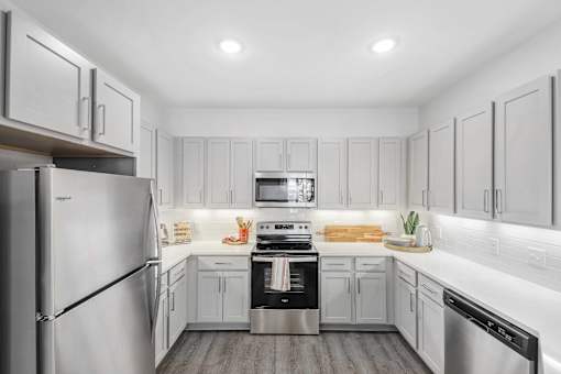 A modern kitchen with stainless steel appliances and white cabinets.