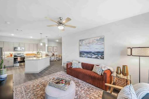 A living room with a red couch and a ceiling fan.
