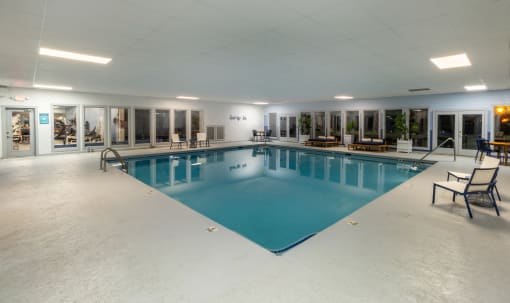 a large indoor swimming pool with lounge chairs and tables at Seven Pines, Alpharetta, GA