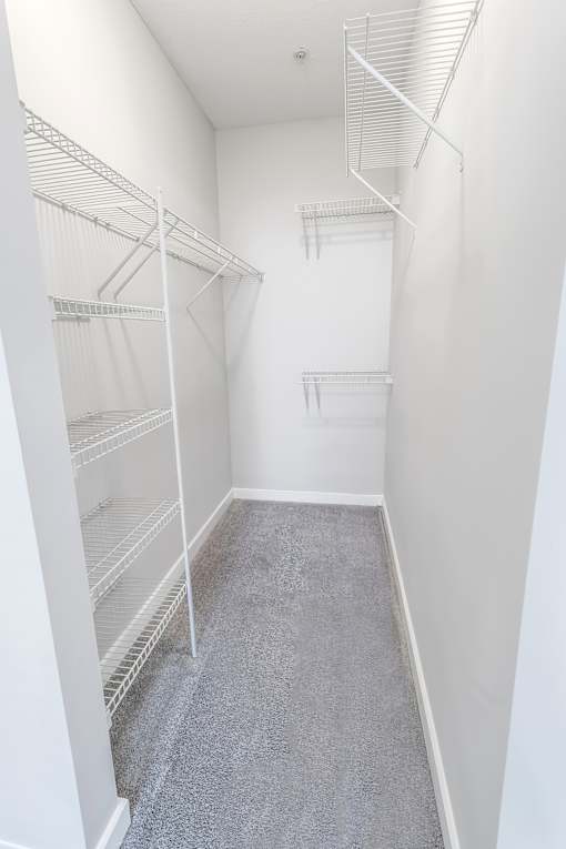 A walk-in closet with white shelving at West Inman Lofts, Atlanta