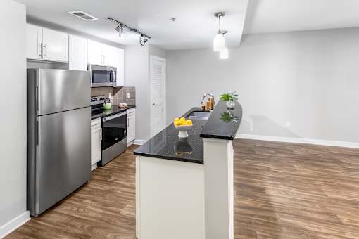A kitchen with a refrigerator, microwave, oven, and sink. at West Inman Lofts, Atlanta, Georgia