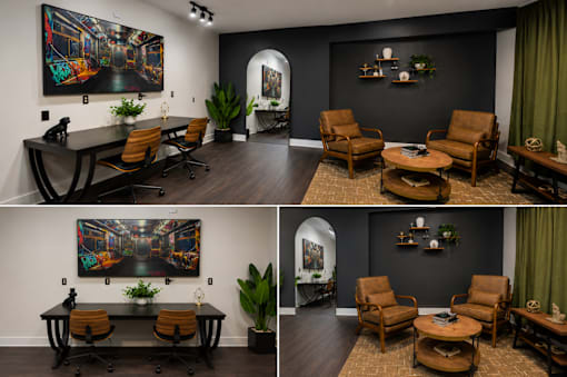 A living room with a black wall and a painting on it.