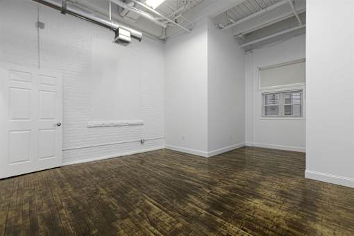 A room with a white door and a window with blinds.