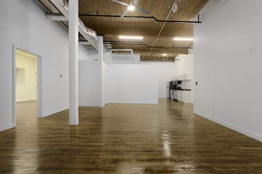 A large empty room with wooden floors and white walls.