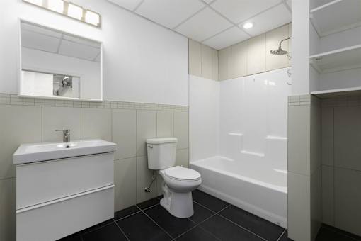 A white bathroom with a toilet, sink, and bathtub.