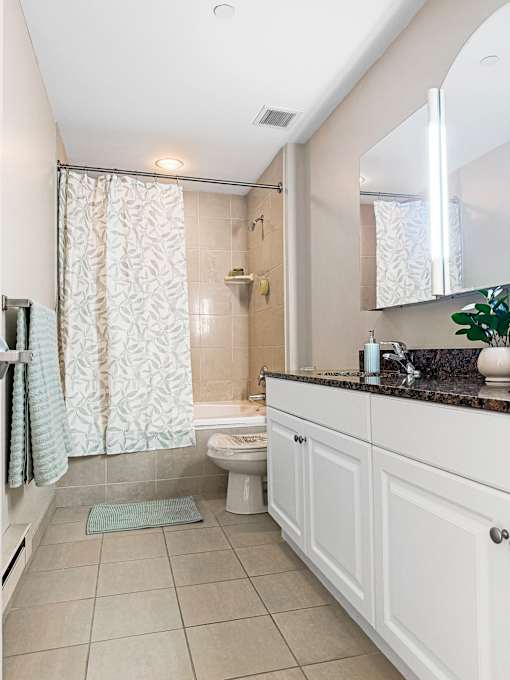 A bathroom with a toilet, sink, and shower.
