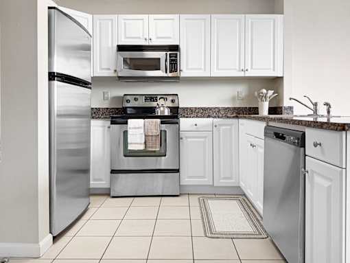 A kitchen with white cabinets and appliances.