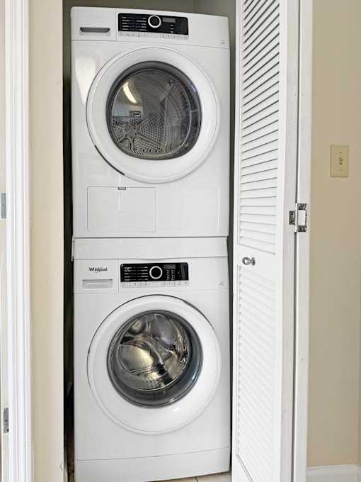 A white Whirlpool washing machine and dryer in a small laundry room.