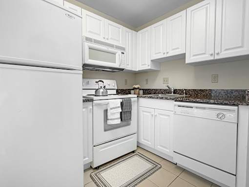 A kitchen with white appliances and cabinets.