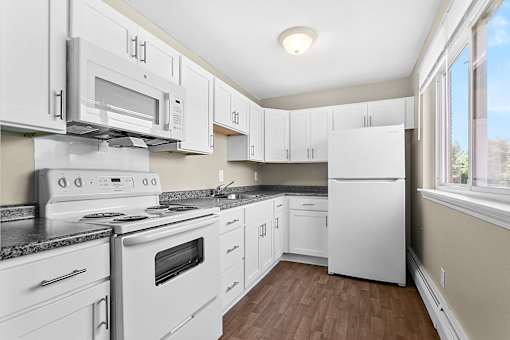 a white kitchen with white appliances and white cabinets at Rose Hill Estates, Norwich, CT, 06360