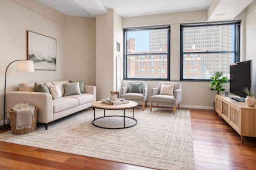 A living room with a white sofa, a coffee table, and a television.