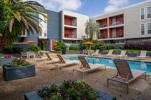 A pool area with lounge chairs and a small pool.
