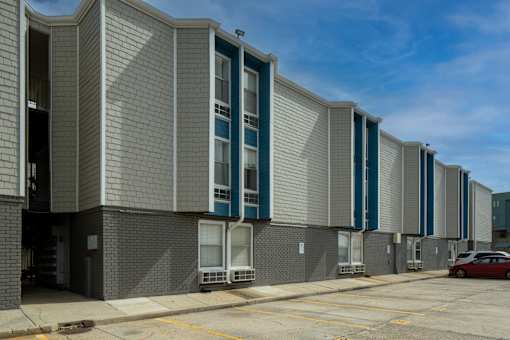 A long building with a grey facade and blue trim.