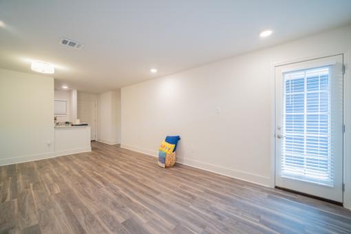 a kitchen and living room with hardwood floors and white walls