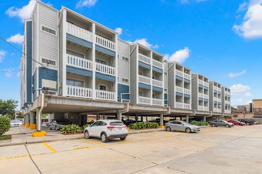 A parking lot in front of a multi-story apartment building.