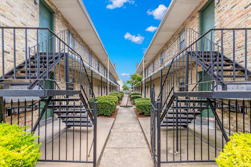 A row of buildings with metal staircases leading to the second floor.