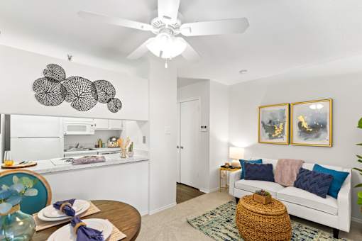 A living room with a white couch and a ceiling fan.