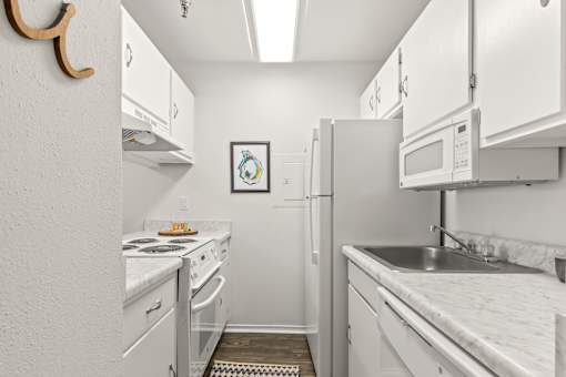 A small kitchen with white appliances and cabinets.