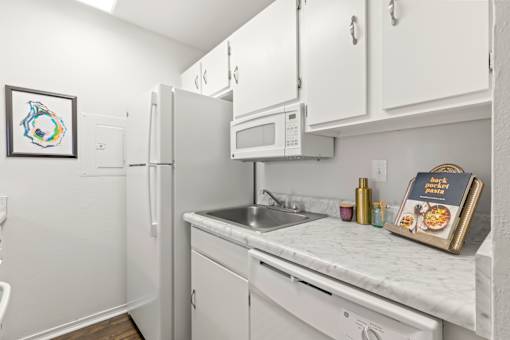 A kitchen with white appliances and cabinets.