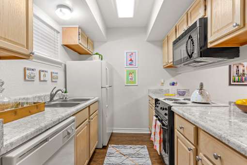 A kitchen with a white fridge and a black microwave.