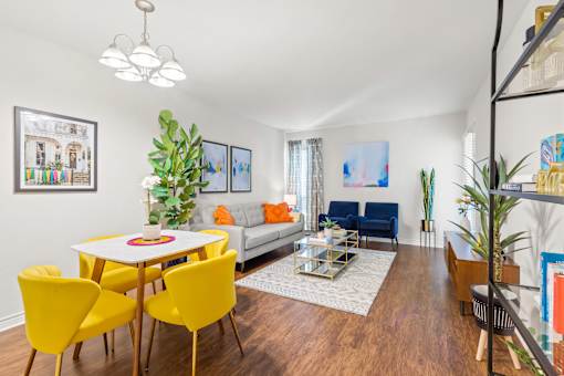 A living room with a white table and yellow chairs.