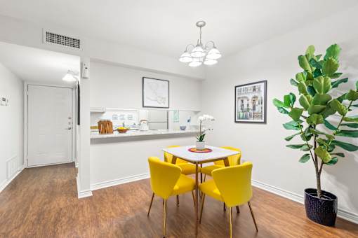 A room with a white table and yellow chairs.