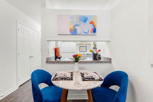A dining room with a table and chairs.