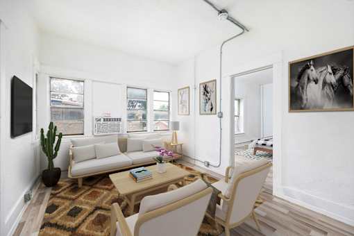A living room with a couch, a chair, a rug, and a painting on the wall.