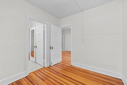 an empty room with wooden floors and white walls