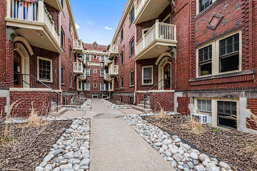an empty walkway between two buildings with rocks and dirt