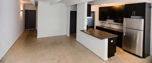 an empty kitchen with a stainless steel refrigerator