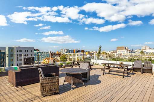 A wooden deck with furniture and a view of the city.