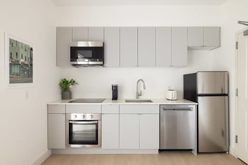 A modern kitchen with stainless steel appliances and white cabinets.