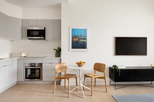 A modern kitchen with a dining table and chairs.