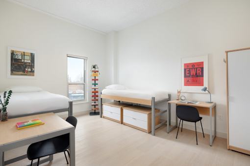 A bedroom with a bed, desk, and chair.