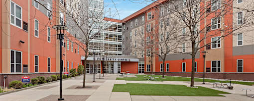 A large building with a glass entrance and a walkway in front.