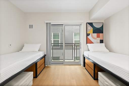 A room with two beds and a large painting on the wall.