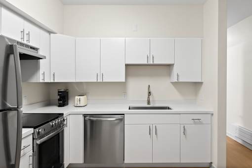 A kitchen with white cabinets and stainless steel appliances.