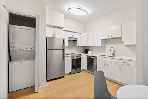 A kitchen with white cabinets and a refrigerator.